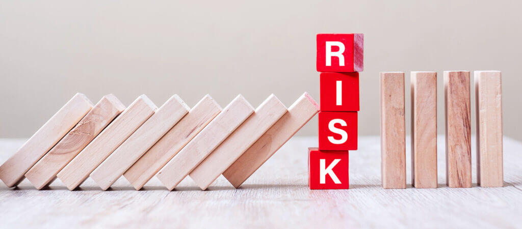 Building blocks arranged to spell RISK within a series of wood blocks.