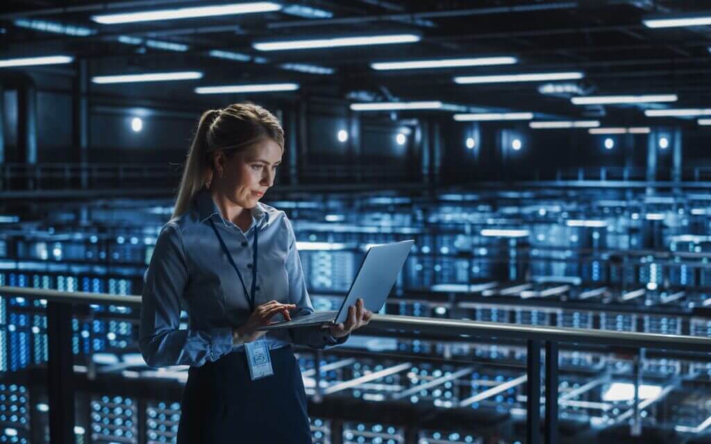 Woman IT employee working in an large server/network room.