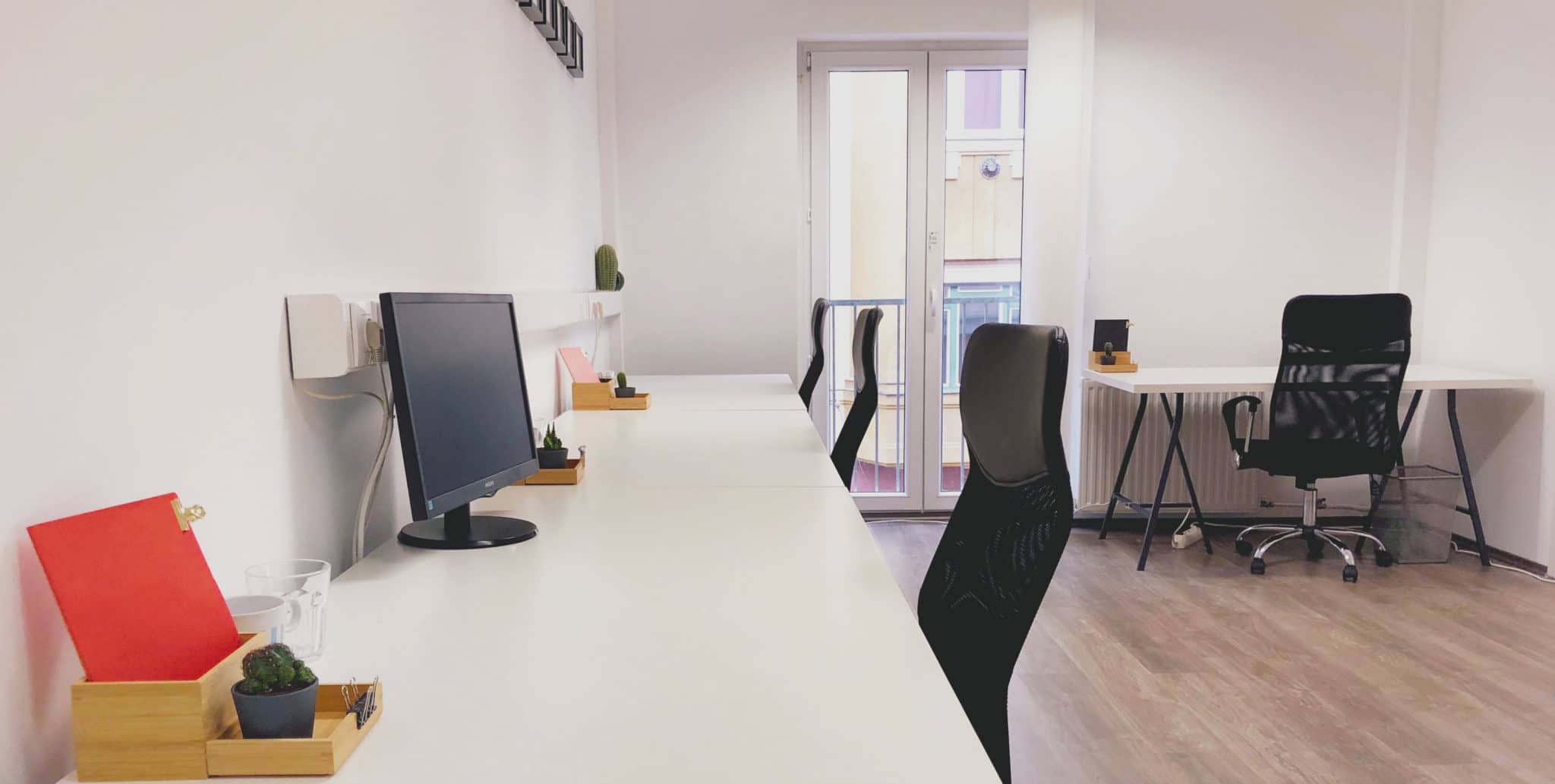 Canva black office rolling chair beside white wooden table.