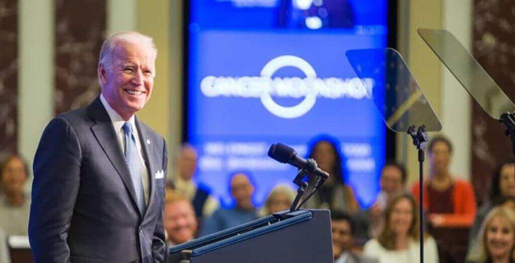 Biden standing behind a podium giving a presentation.