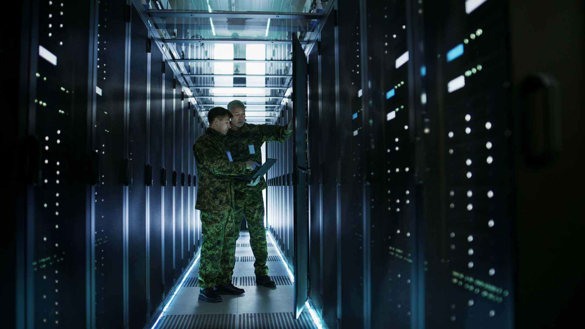 Department of Defense officers in a network/server room.