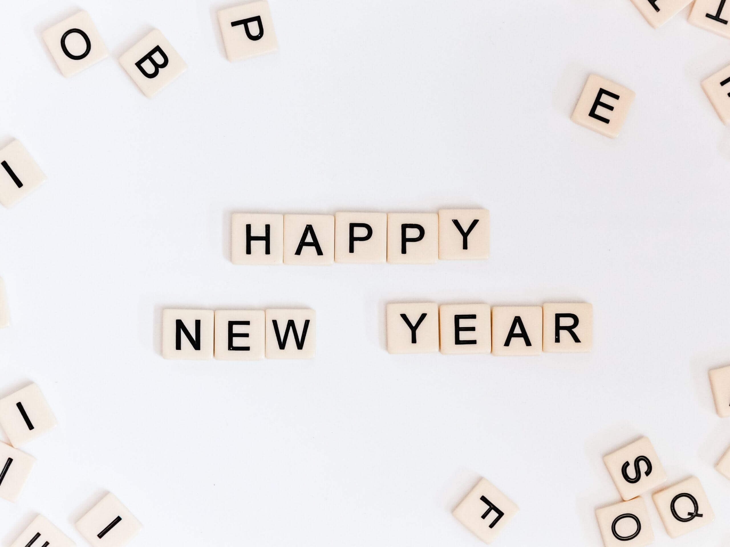 Happy New Year spelled out in scrabble pieces.